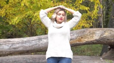 Slow Motion Autumn kadını sonbahar parkında. Sıcak güneşli hava. Sonbahar kavramı