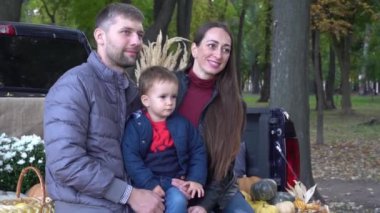 Slow Motion Happy family with pumpkin on autumn leaves. Outdoor.