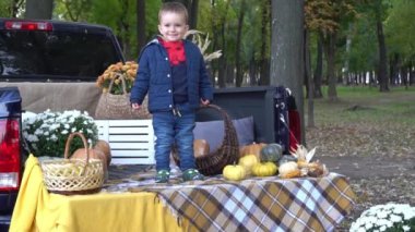 Slow Motion. Neşeli ve komik bir erkek bebek süslü bir arabanın bagajında oturuyor.