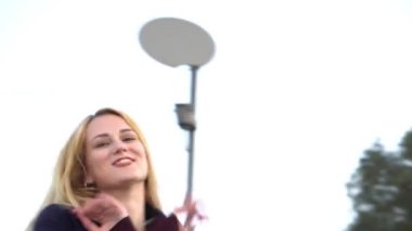 4K Kız sokakta müzik dinliyor ve dans ediyor.