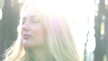 Slow Motion beyaz kadın mutlu bir şekilde gülümsüyor güneşli yaz ya da bahar gününde 