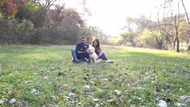 Glücklich Schöne Familie Mit Hund Spaß Haben Sitzen Auf Gras — Stockvideo