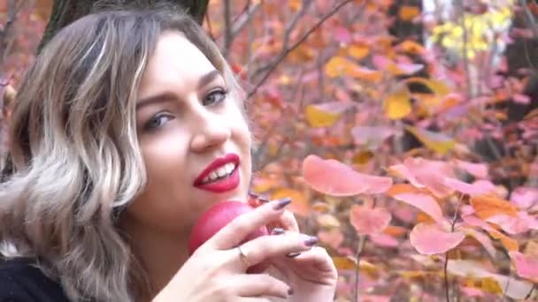 Young Pretty Woman Sitting Fallen Red Maple Leaves Holding Apple — Stockvideo