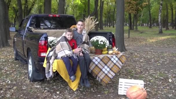 Niedliche Kleine Jungen Mit Einem Kürbis Sitzen Auf Kofferraum Des — Stockvideo