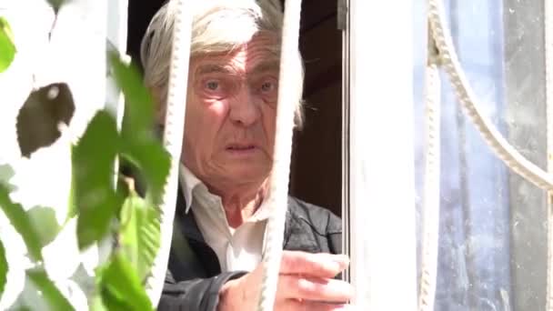 Smutny Samotny Staruszek Patrzący Przez Okno Zachodzie Słońca — Wideo stockowe
