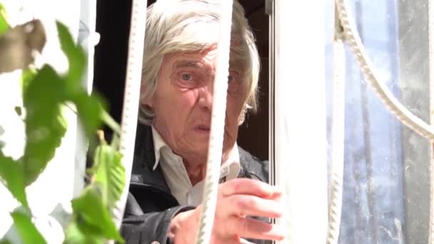 Печальный Одинокий Старичок Выглядывающий Окна Закате — стоковое видео