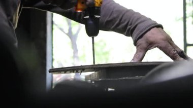 Tanınmayan bir işçi Neiva, Huila, Kolombiya 'daki bir marangoz atölyesinde kablosuz bir elektrikli matkapla odun çıkarıyor. Sanayi ve el yapımı kavramı