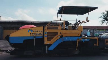 Seçici odaklanma. Yol asfaltlama işlemi. Ağır kaldırım makinesi asfalt yol onarımı üzerinde çalışıyor. 