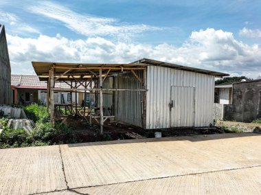 Multiplex ahşap binanın yan görüntüsü - gecekondular ya da konut kompleksi inşa etme sürecindeki proje depoları. Geçici binalar ya da Endonezya 'daki depolar. Endonezya - 02.24.2026.