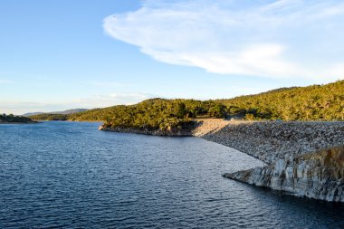 Lake Jindabyne in the shadows of mountain range and cloudscape clipart
