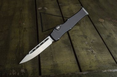 Yeşil bir kutuda büyük otomatik bıçak. Alçak tuş.