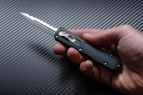 Small compact knife in hand. Knife open in hand. Top.
