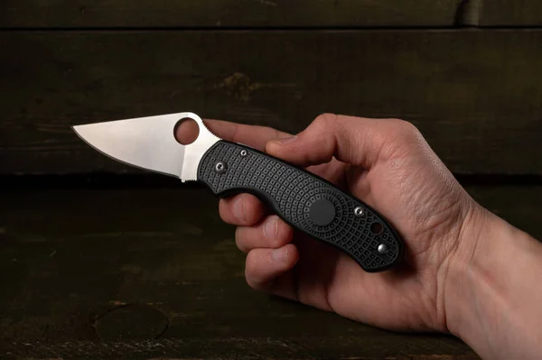 Compact little knife in hand. A knife with a lightweight handle. Knife in hand. Hand holding a knife.