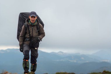 Dağlarda büyük sırt çantalı bir turist. Turist dağlarda yürür. Dağ manzarası.