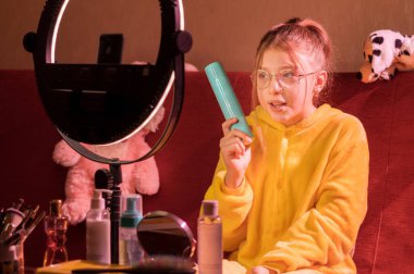 Kız objeyi kameraya gösteriyor. Ürünün reklamını kameraya yapıyor..