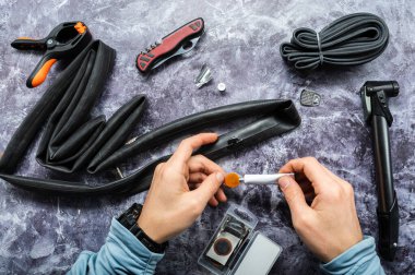 Hazırlanan yamaya yapıştırıcı sürülüyor. Tüpü onarmak için yama. Lastik yama ve yapıştırıcı. Üst.