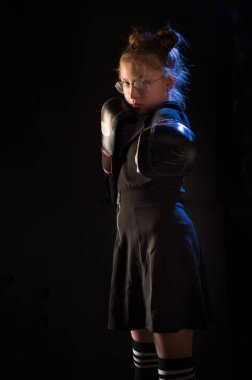 Kız ön yumruğu vuruyor. Boks eldivenli bir kız düz yumruk atıyor. Boks yapan bir kız. Boksör kız.