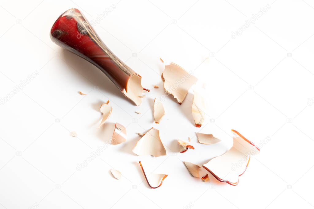 The flower vase is broken into pieces. Broken glass vase. White background. Top.