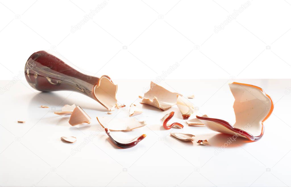 Broken glass to pieces. Lots of small glass from a vase. Superstition. Vase on a white background. Top.