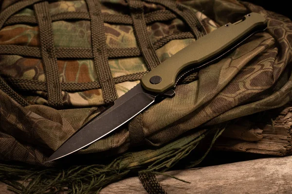 A pocket knife on a military uniform. Military uniform and knife.