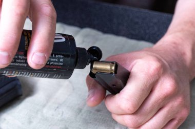 Şarjörü mermilerle yağla. Yağlama yağı ve silah dergisi. Makro.