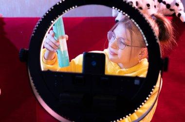 Kız, yazıya ve ürünün ismine işaret ediyor. Kız şişenin bileşimini gösteriyor..