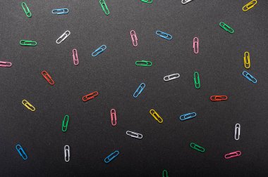 Siyah arka planda çok renkli desenler var. Siyah arkaplanda çok renkli ataçlar.