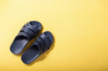 Sarı arka planda ev terlikleri. Sarı arka planda lastik terlikler..