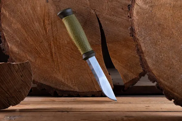 Scandinavian knife on the background of the stump. Swiss knife on a wooden background. Front view.