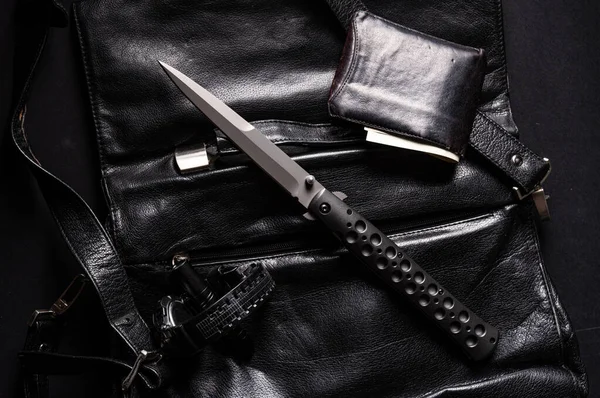 一把锋利的大刀和一个钱袋 皮制公文包上的刀时钟和灯笼 黑色物品在黑色 — 图库照片