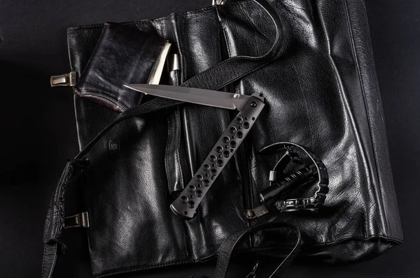 革袋の上に半折りの位置に大きな折りたたみナイフ。メンズ財布と時計. — ストック写真