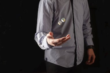 Gömlekli adam zarı atıyor. Zarlar havada süzülüyor..