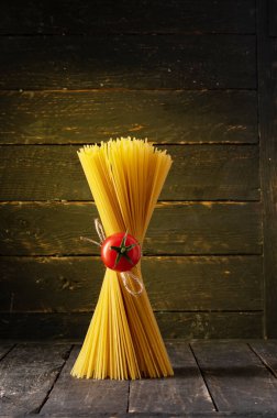 Spagetti ve kiraz domatesli kompozisyon. Makarnanın ortasına domates..