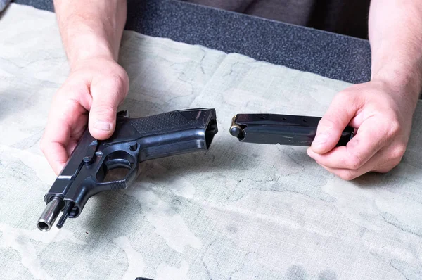 El dueño de la pistola inserta el cargador en la pistola. Carguen el arma. Inserte el clip en la pistola. — Foto de Stock