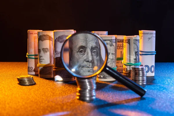 Büyüteçle para. Banknotlar ve paralar masanın üzerinde. Alçak tuş.
