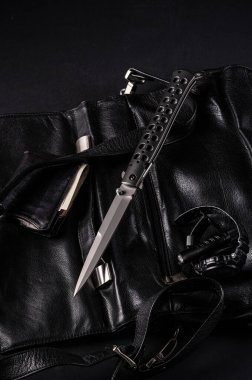 Siyahlı erkek aksesuarları. Siyah stili. Büyük katlanmış bıçak, saat, cep feneri ve cüzdan. Dikey çerçeve.