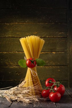 Spagetti ve domates. Spagetti ve buğday dikenleri. Spagetti ve köy usulü. Dikey çerçeve.