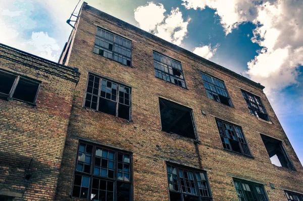 Ett gammalt övergivet hus. Fabrik med stora fönster. Husets bottenvy. Övergiven fabrik. En gammal tegelbyggnad. — Stockfoto