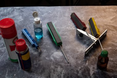 Bir keskinleştirme taşı seti. Keskinleştirme taşları ve yağlama yağları. Öğütücü. Bir açıyla üstteki görünüm.