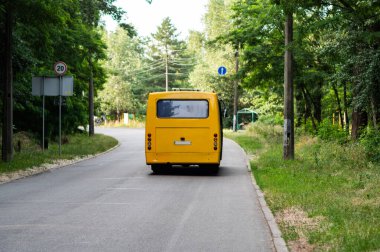 Otobüs kalkıyor. Otobüsün arka manzarası. Otobüs dar bir yol boyunca sürüyordu. Parkta yolcu taşımacılığı.