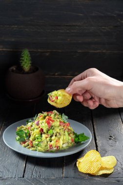 Patatesli salata ye. Meksika salatası ve patates kızartması. El ve salata. Dikey çerçeve.