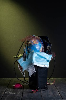 Ekoloji ve doğa koruma üzerine güçlü bir görsel açıklama. Fotoğrafta, bir dizi atılmış eşyayla dolu, taşmış bir çöp kutusu var..