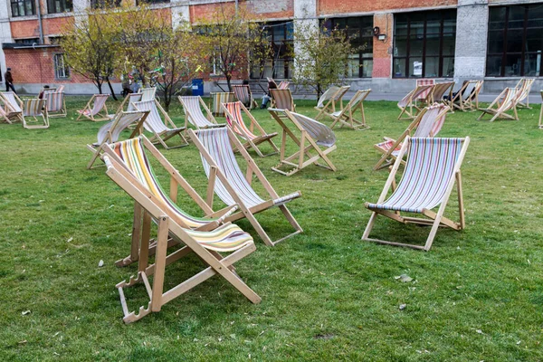 Şezlong yeşil çimlerin üstünde. Yaz sandalye. Dışarıda pek çok yaz sandalye.