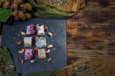 Çok renkli rakat lukum. Taze yeşil üzümler. Üst Manzara. Karanlık ruh hali bileşimi.