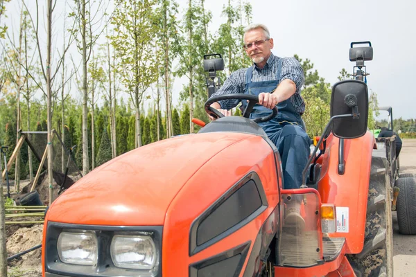 Gärtner am Steuer eines Traktors — Stockfoto