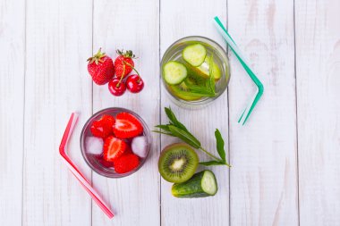 İki bardak su ve kivi, salatalık, nane, çilek, kiraz yakınındaki tübüllerin ile meyve