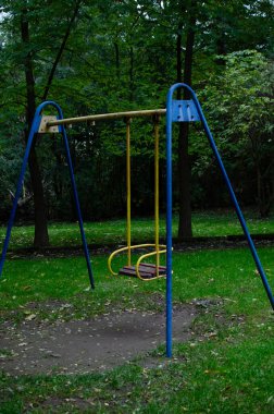 Parkta boş bir salıncak seti. Sakin, nostaljik bir sahne. Çocukluk ve eğlence için mükemmel.