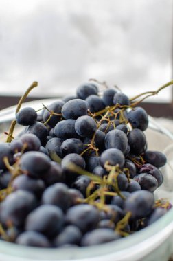 Bir kase koyu üzüm sergilenir. Bu ürünü sağlıklı beslenme reklamları için kullanın.