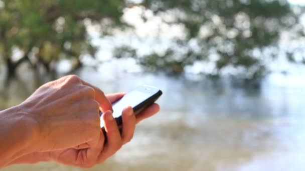 Närbild på Man händerna med Smartphone, natur bakgrund. — Stockvideo