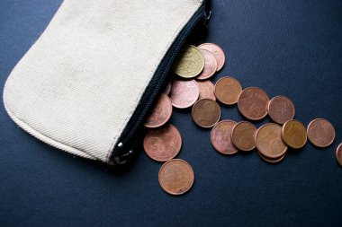 Siyah arka planda 1 avro bozuk para olan fermuar cüzdan.